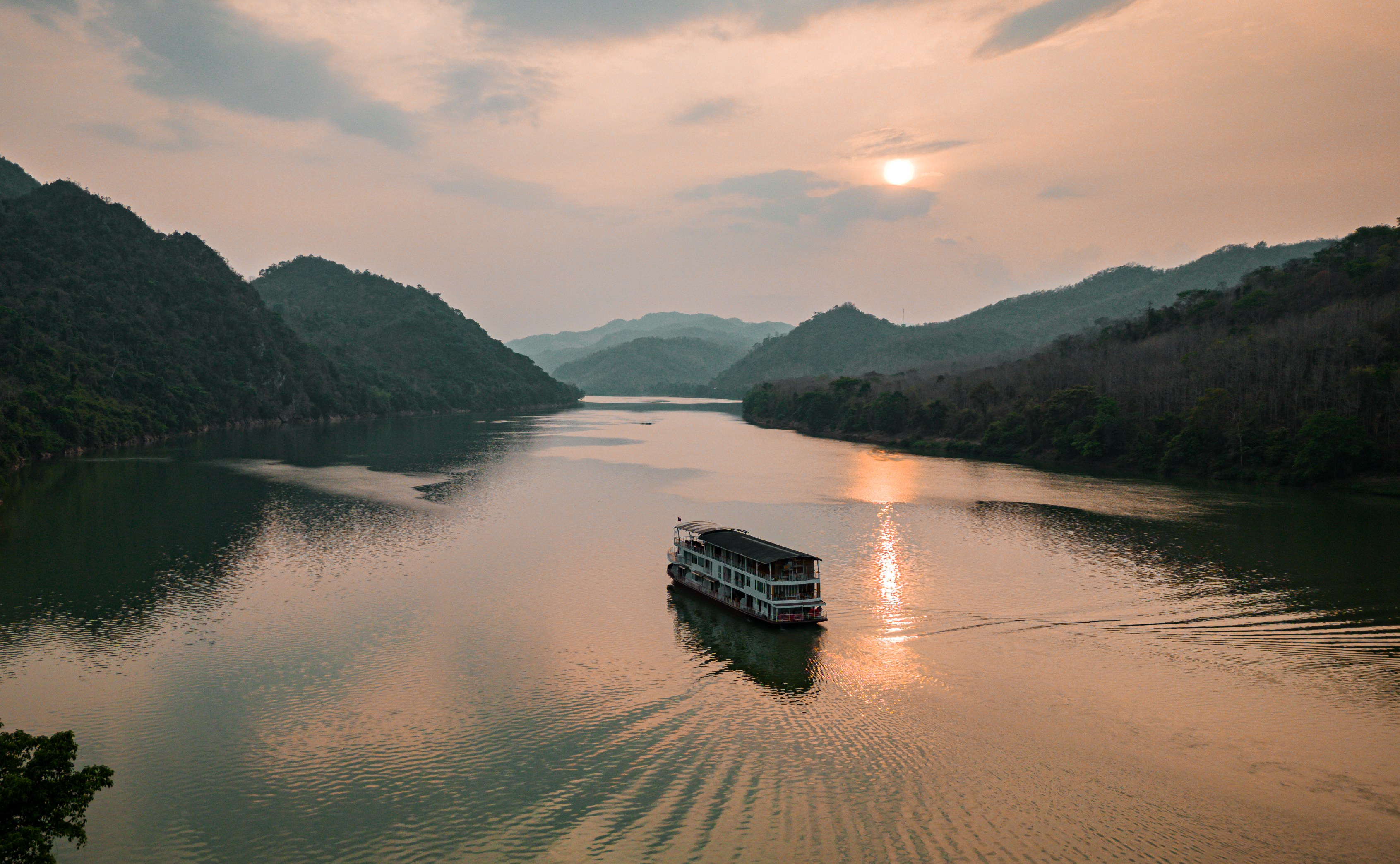 River cruise boat on the Mekong River at sunset.