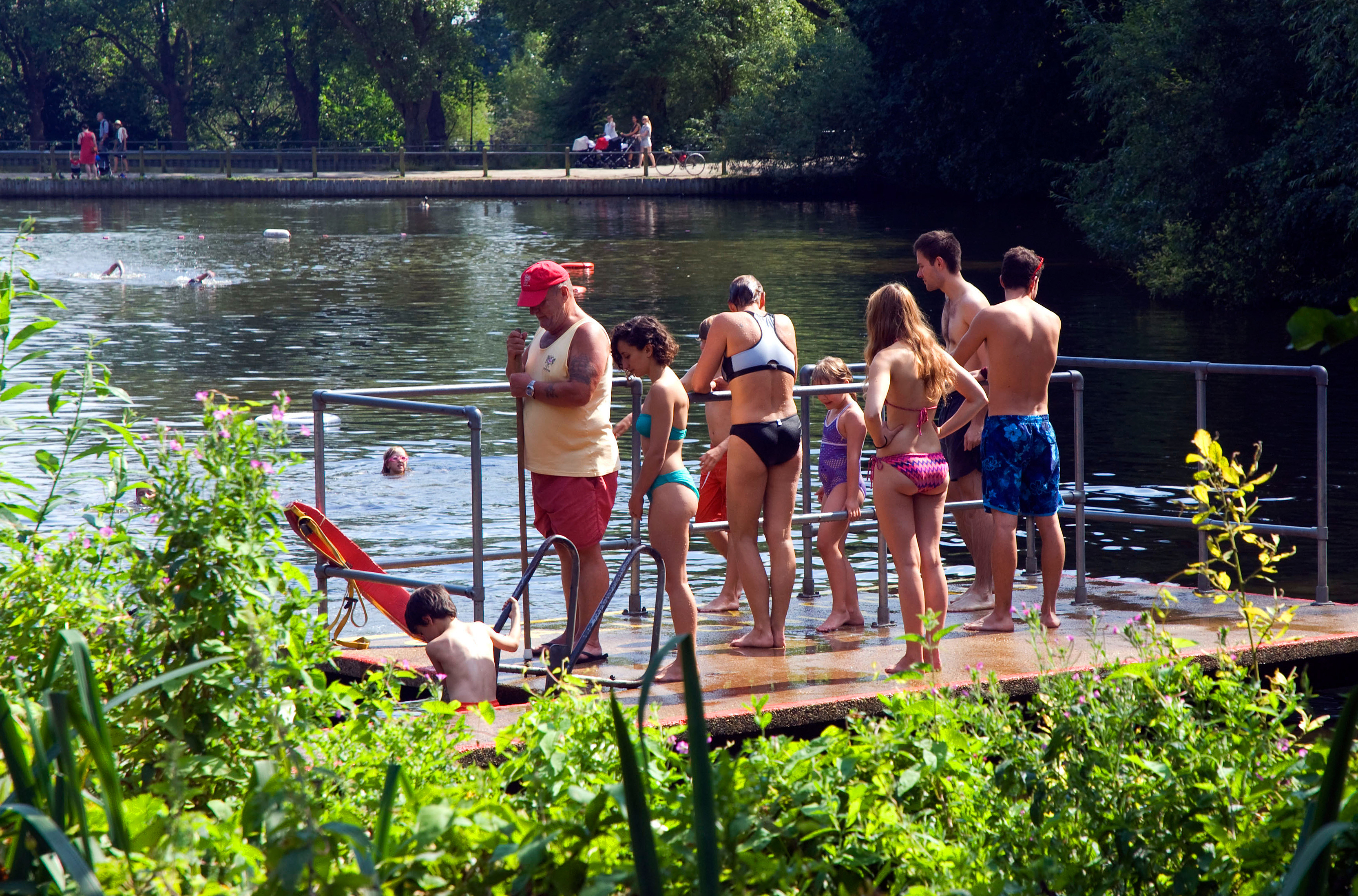 Swimmers relax on a pier at the mixed pond on Hampstead Heath in London