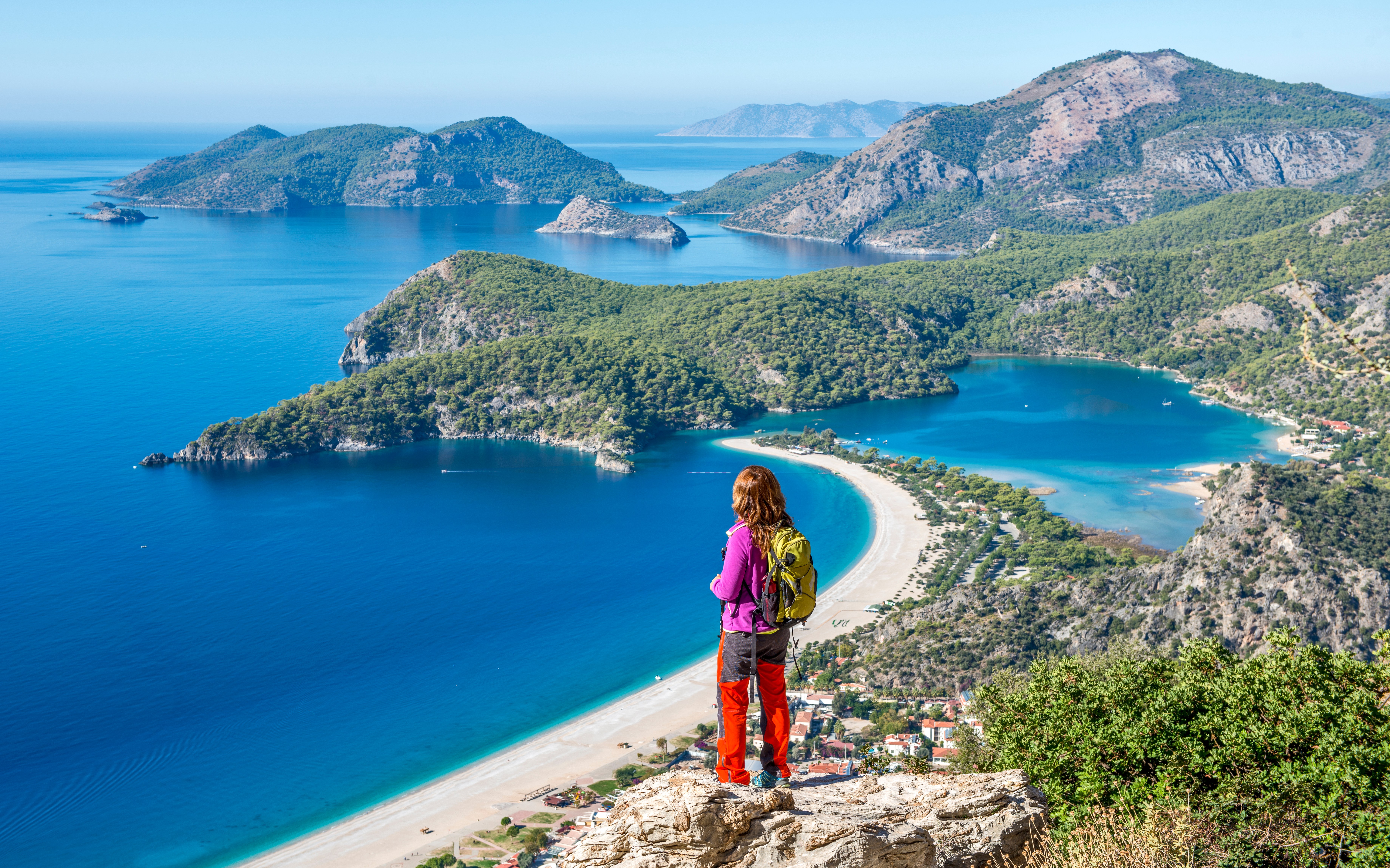Hiker overlooking a beach and turquoise water on the Lycian Way.