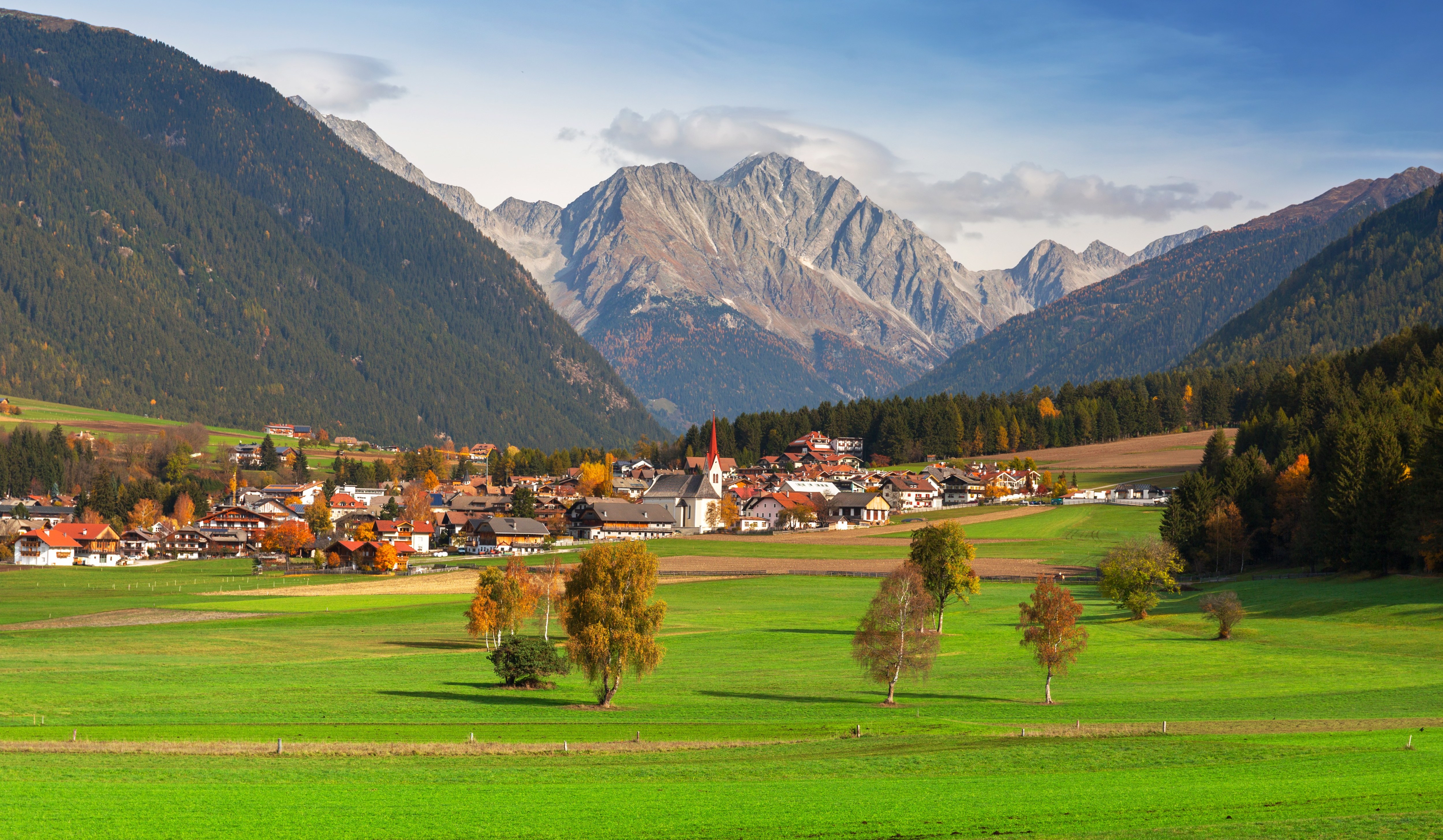 a small village in the mountains with a church in the middle