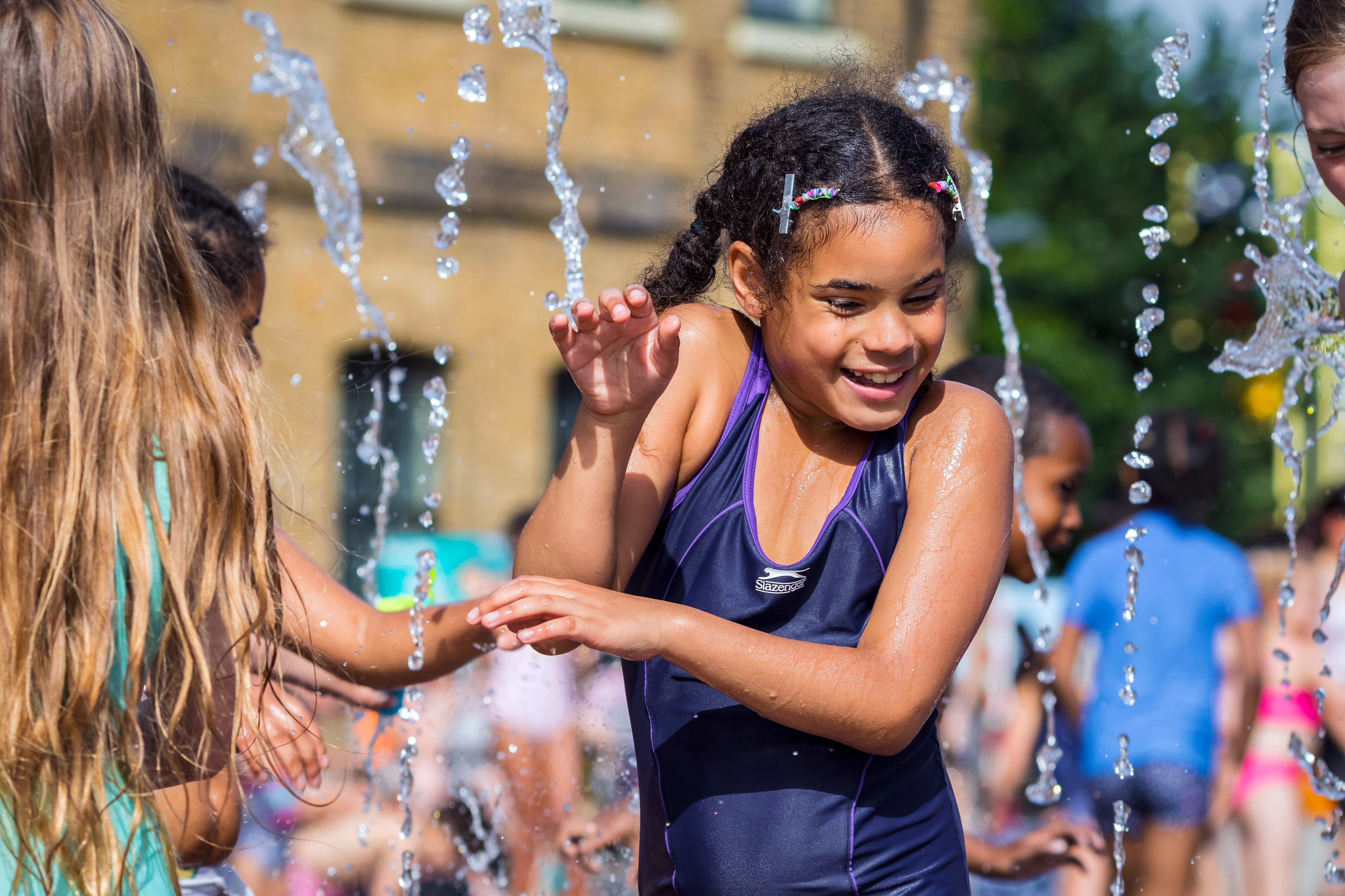 Children playing in a water fountain at Granary Square in King's Cross, London