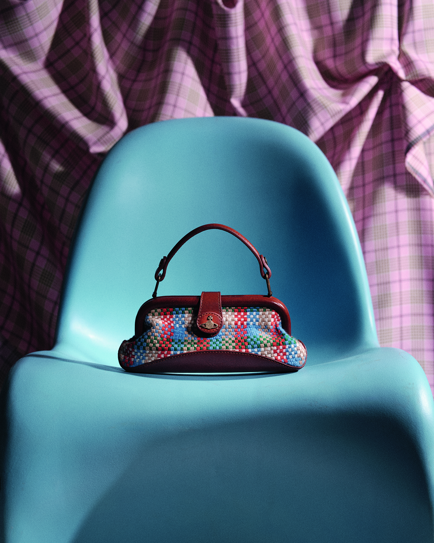 Small patterned handbag on a blue chair.